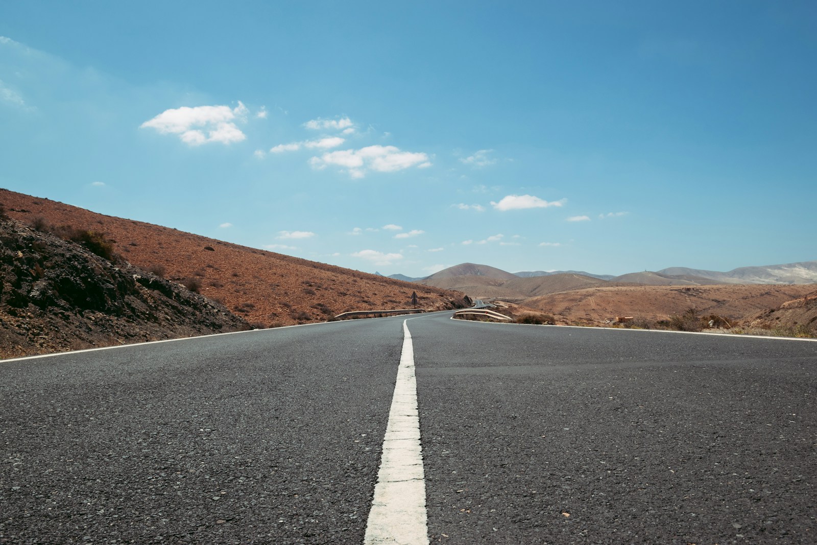 empty road between brown grasses